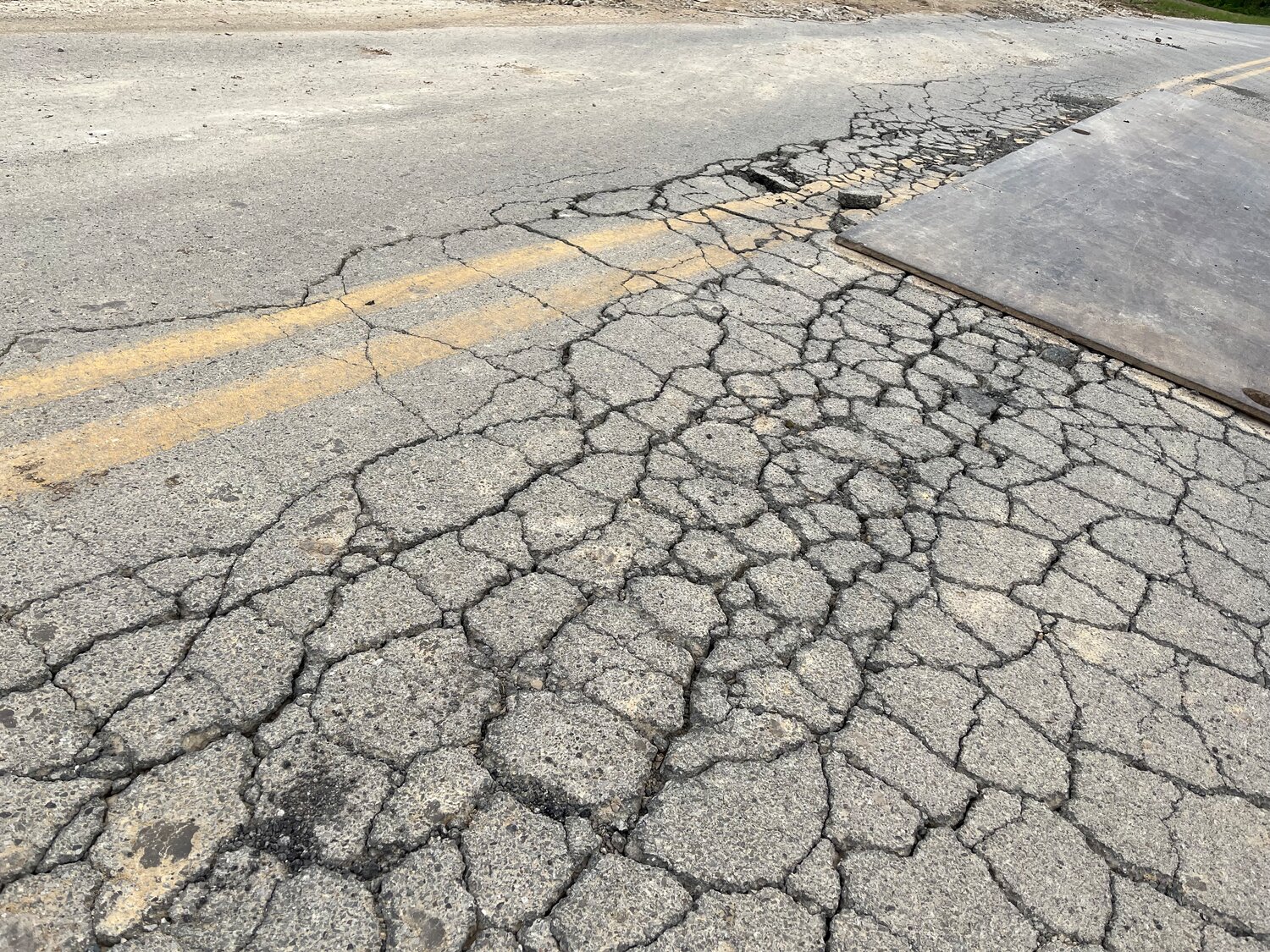 DAMAGED ROAD - Cracks in the asphalt of Roelker Road show the level of destruction the current street has suffered.