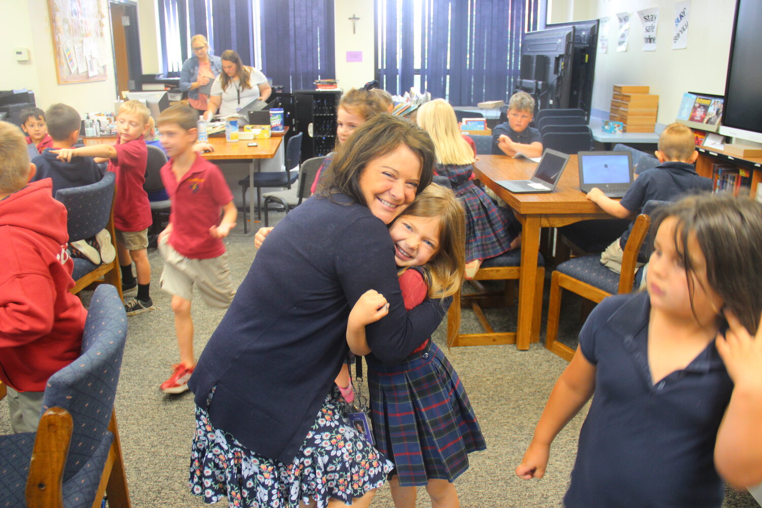Holy Rosary Principal Lori Racine gets a hug from kindergartner Charlotte Boller in the school library on May 15. Charlotte and her classmates were preparing for technology class.