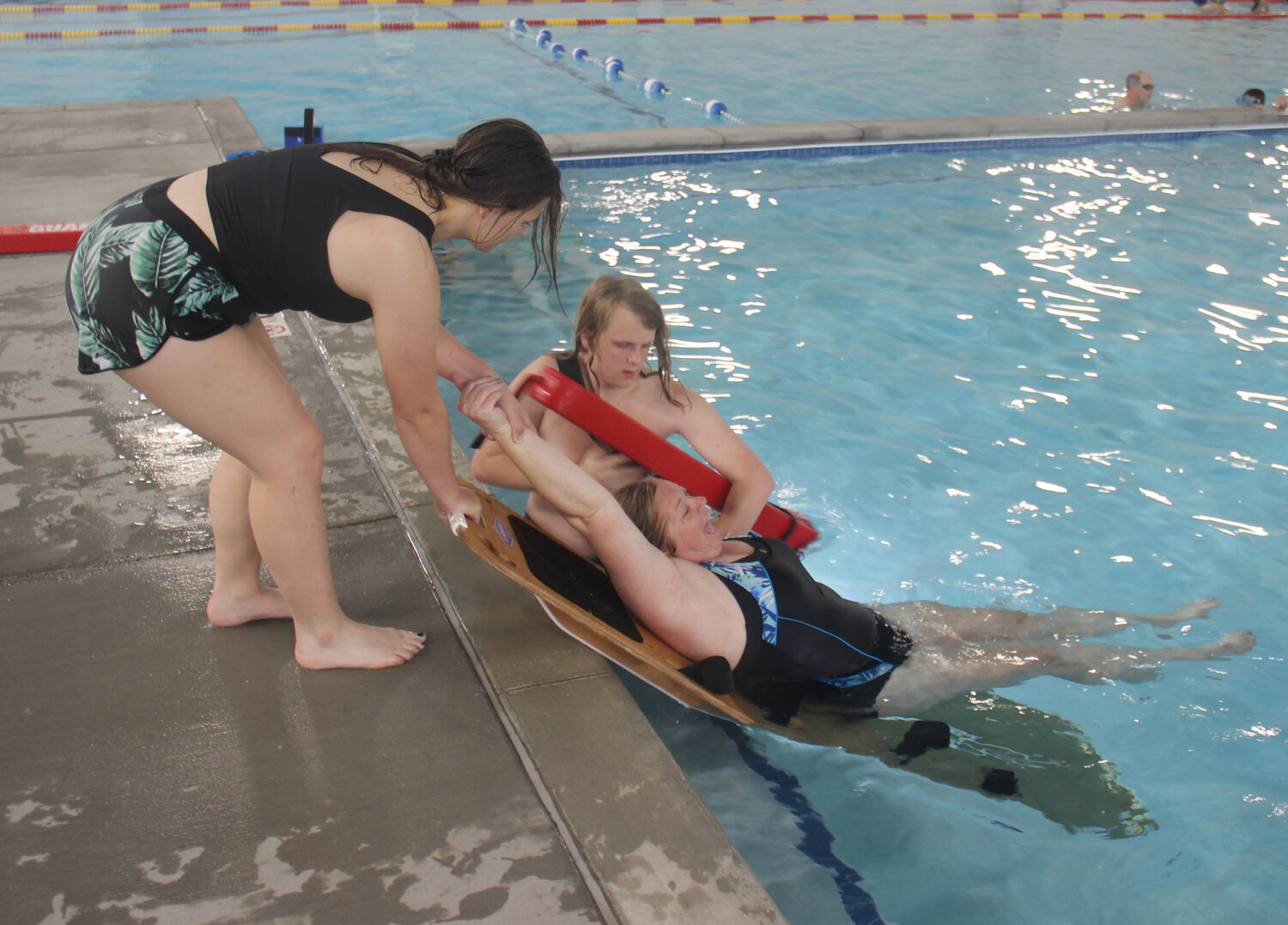 Miakoda Rose and Hunter Grube work together to "rescue" fellow lifeguard candidate Tamara Wurth from the water during training on May 19.