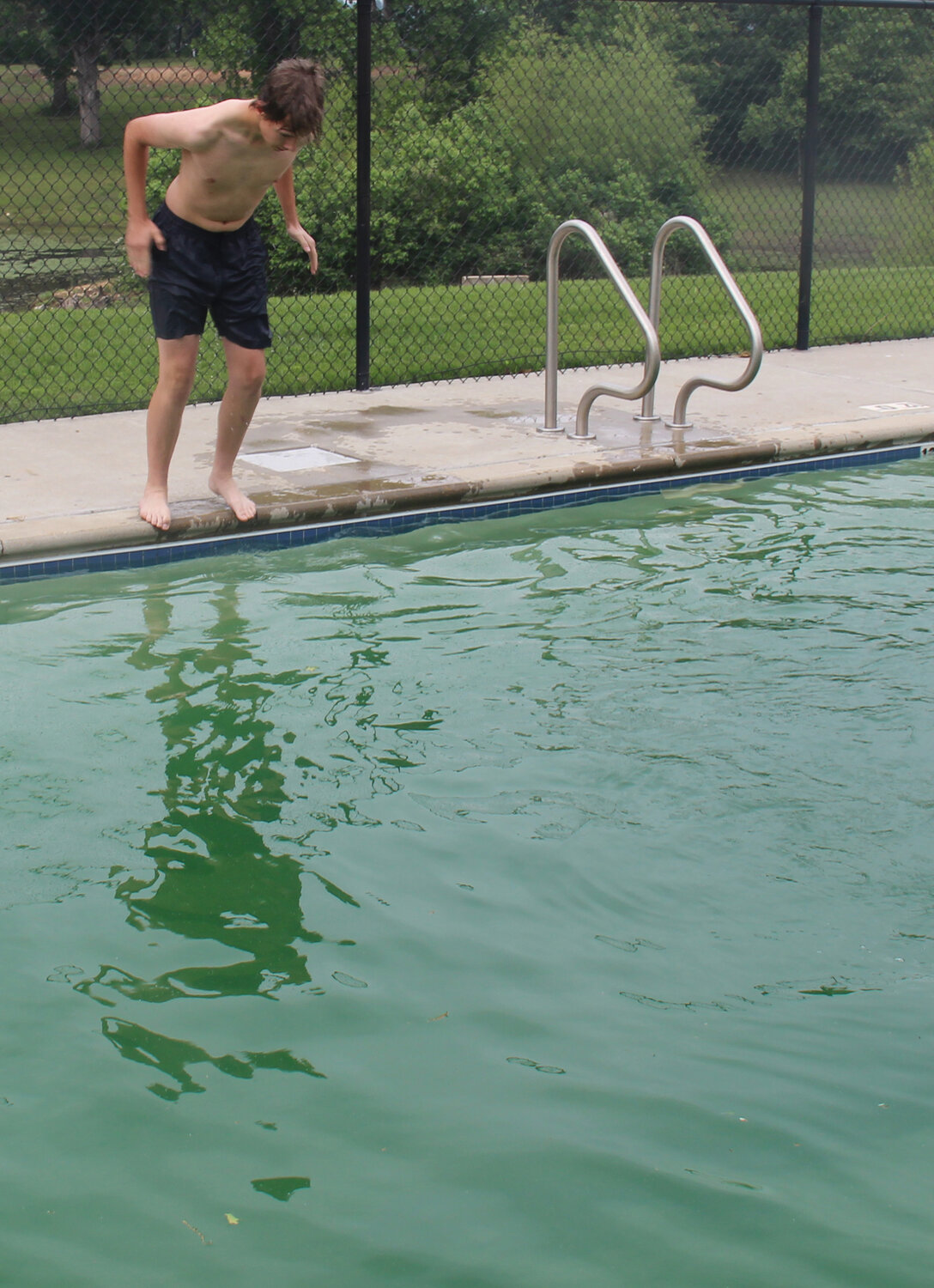 Nathanial Kutsch prepares to jump into the outdoor pool at the Warrenton Aquatic Center to retrieve the brick. The outdoor pool is 12-feet deep.
