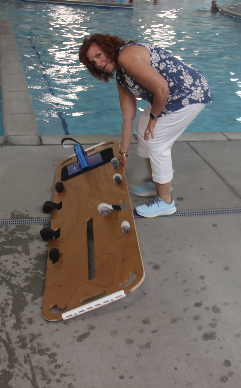 Lisa Kramer aquatics director, brings the backboard to the pool for the lifeguard training.