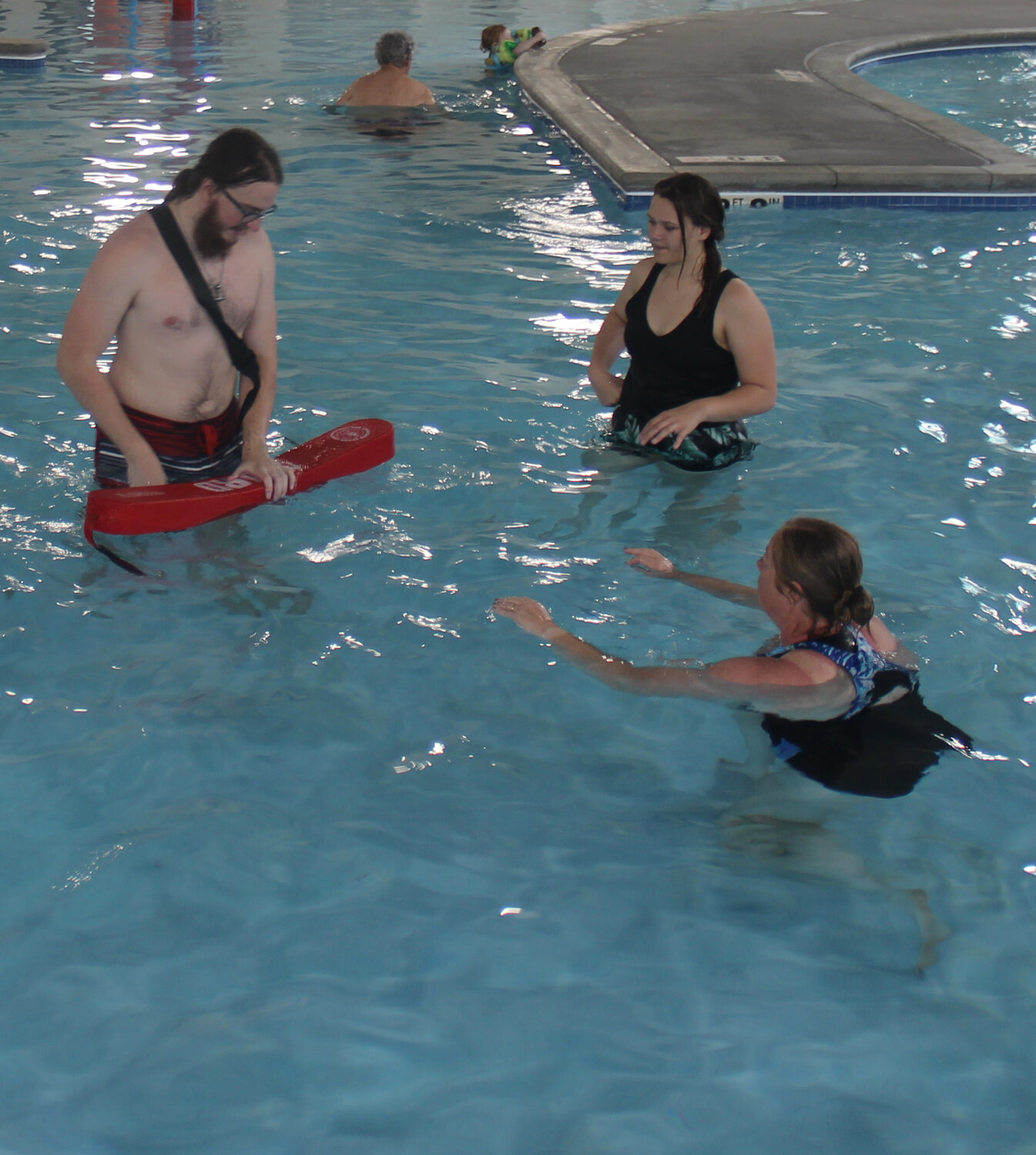 Cole McBride works with Miakoda Rhodes and Tamara Wurth during lifeguard training on May 19.