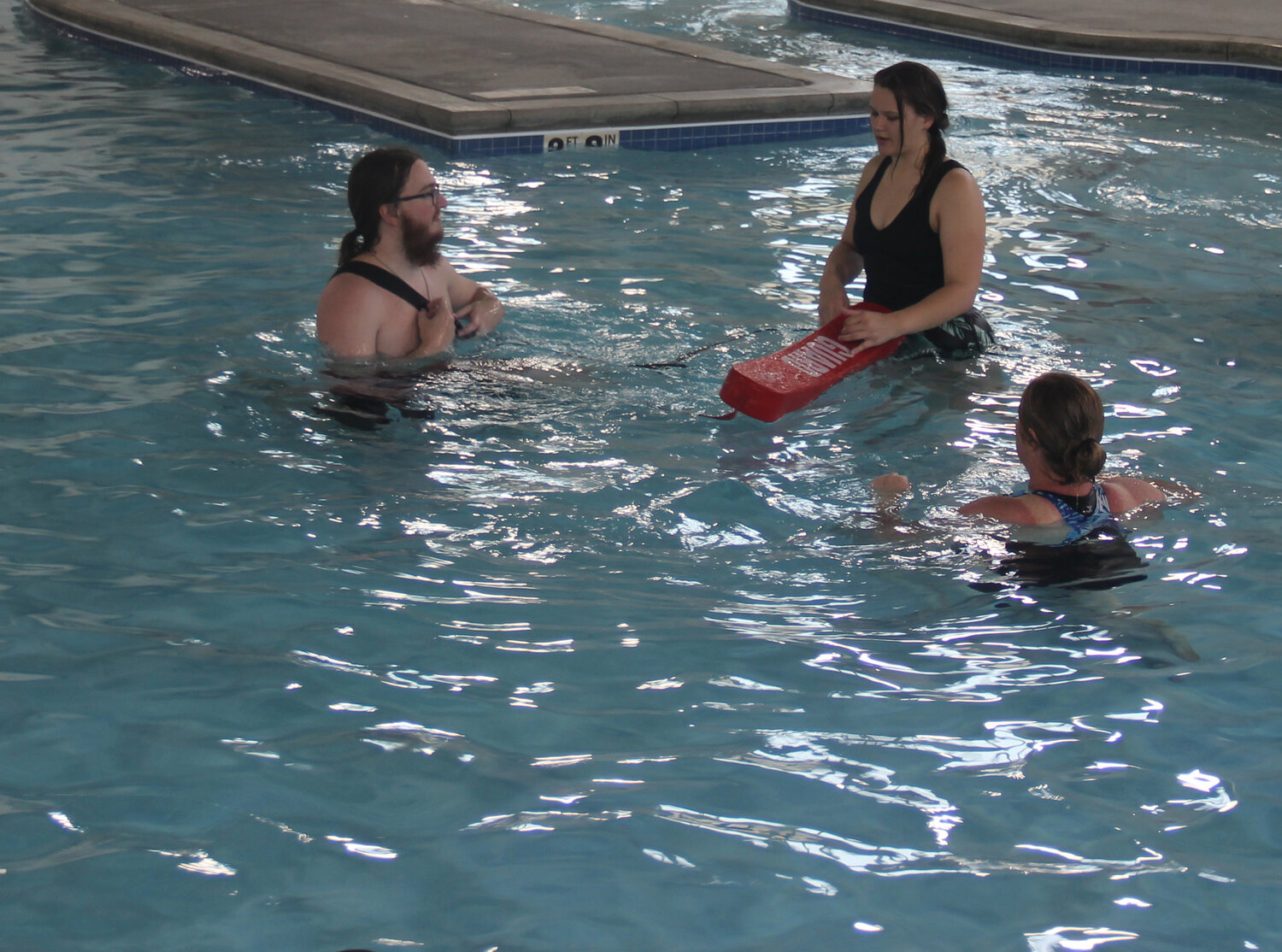 Cole McBride offers instructions to Miakoda Rhodes and Tamara Wurth during lifeguard training class.