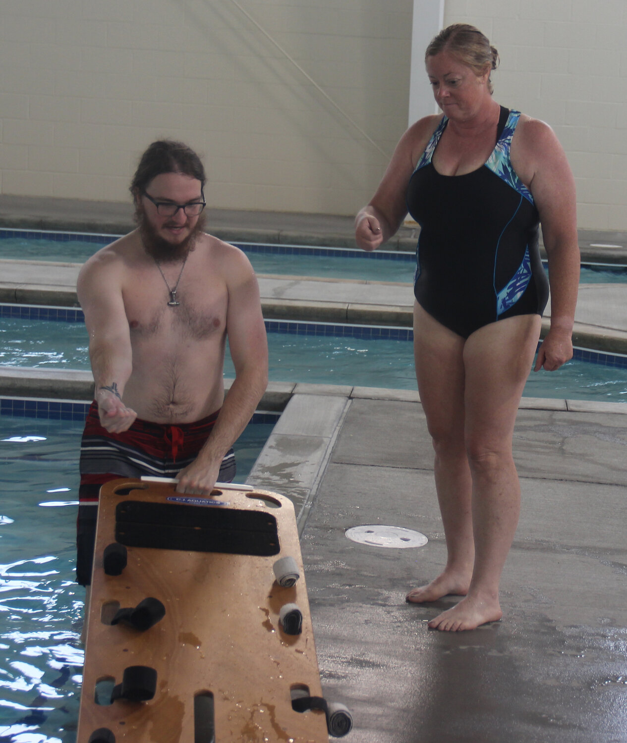 Cole McBride works with lifeguard candidate Tamara Wurth on backboard technique.