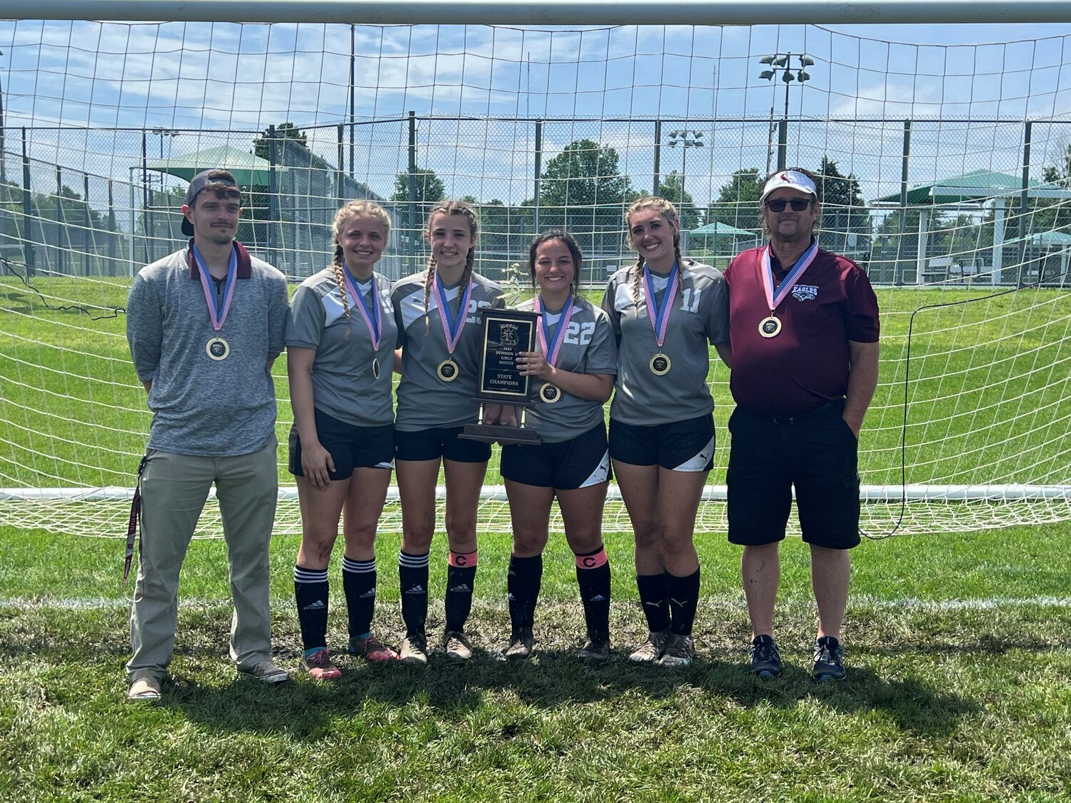 Liberty Christian seniors Alli Meyer (second from left), Anna Meyer (third from left), Joy Kassebaum (third from right) and Kylee Ball (second from right) pose with the championship plaque after winning the MCSAA soccer championship.