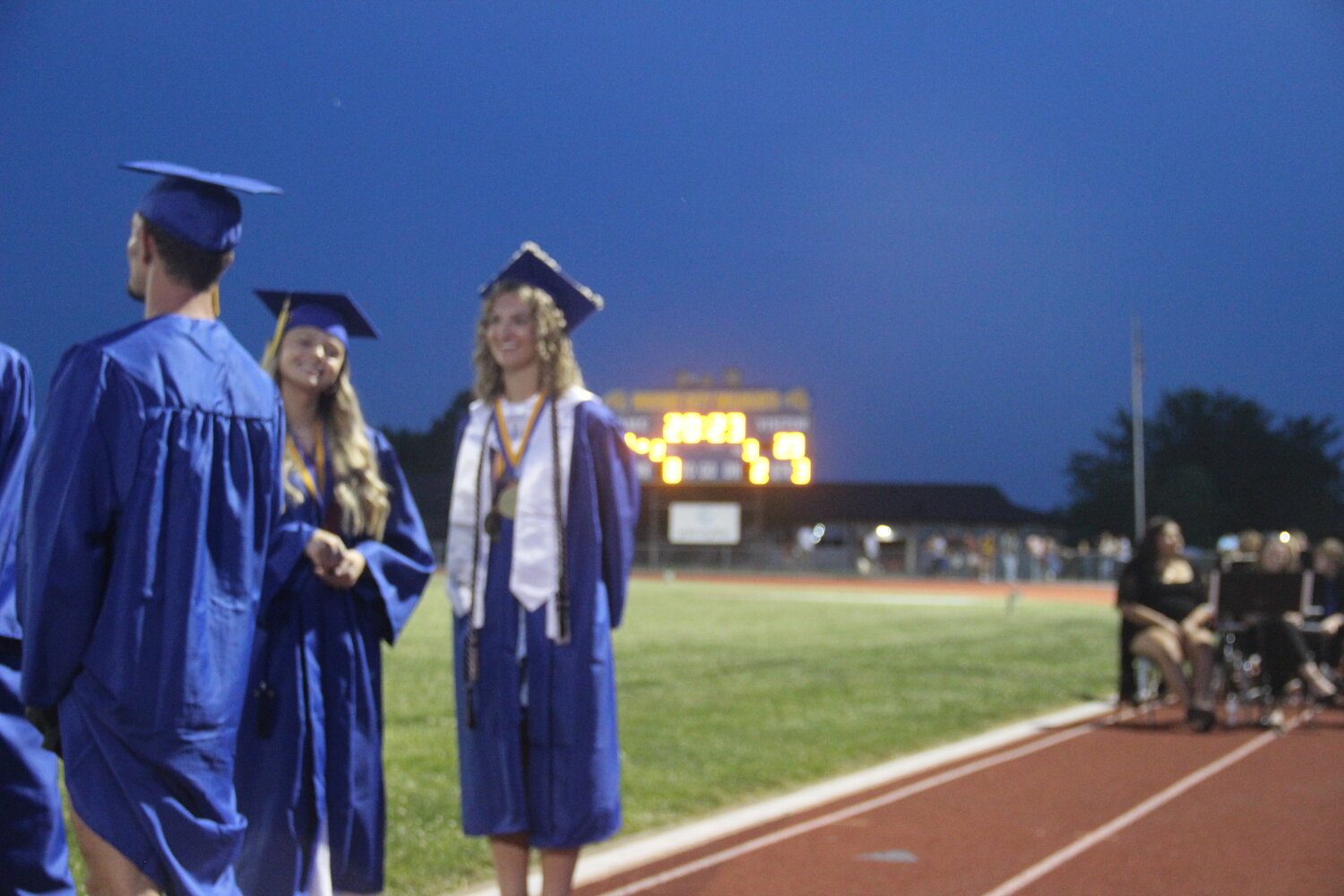 Katy Novak and Victoria Orf wait in line for their chance to cross the stage and have their name announced to the crowd during the Wright City High School graduation ceremony.