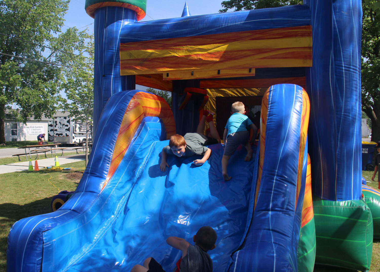 Kids enjoy the bounce-house slide on a warm Saturday afternoon in Truesdale during Summerfest.