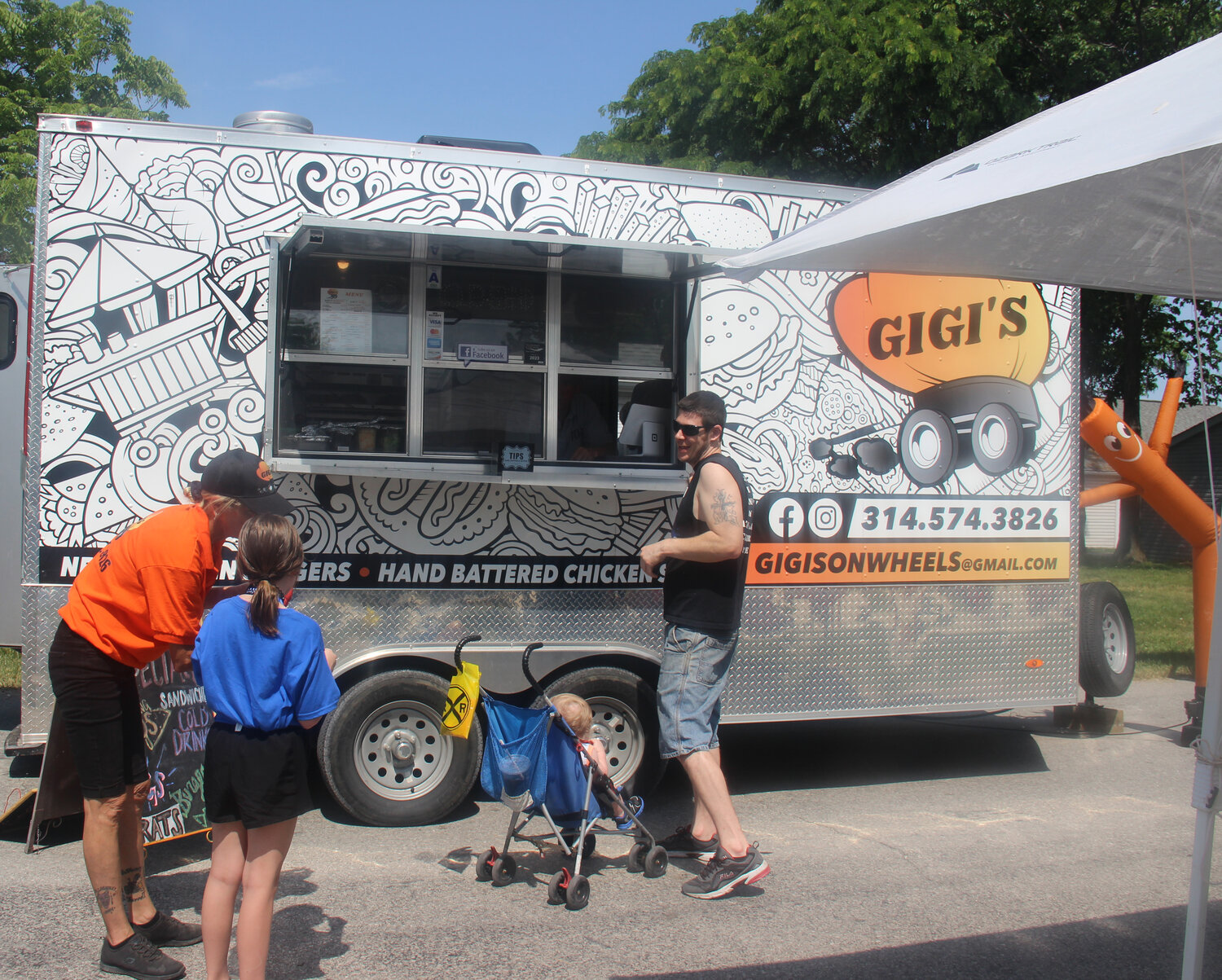 A family orders food from one of the several food trucks serving Summerfest attendees.