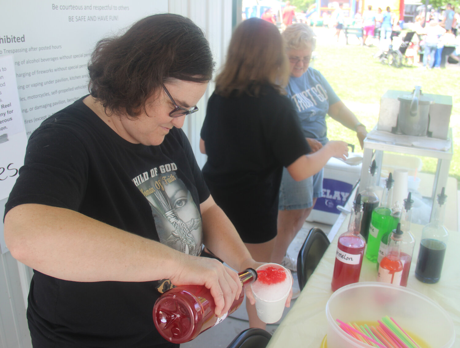 Mary Horn pours syrup into a sno-cone during Summerfest in Truesdale.