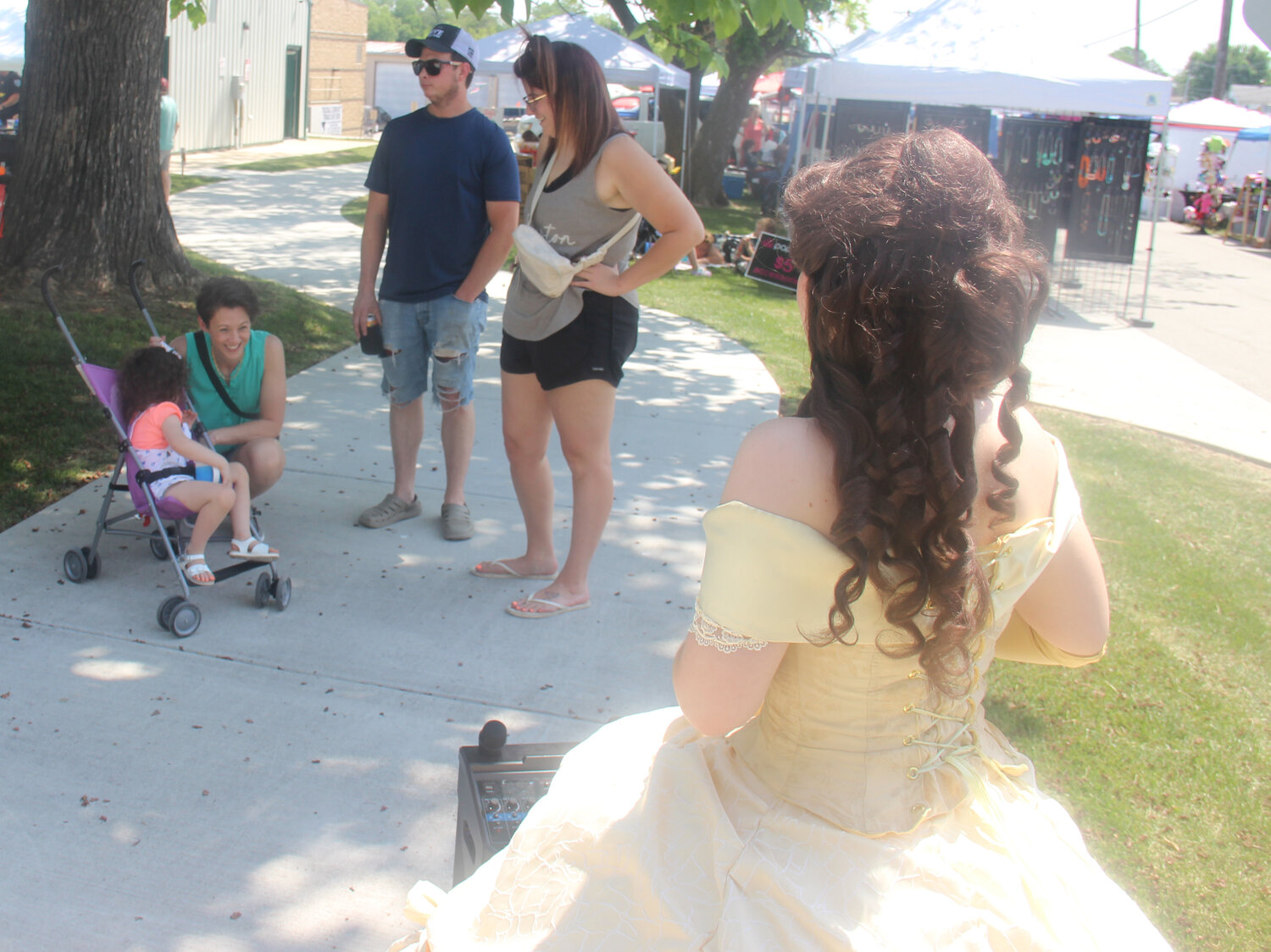 A young child gets shy as Princess Belle approaches during Summerfest.