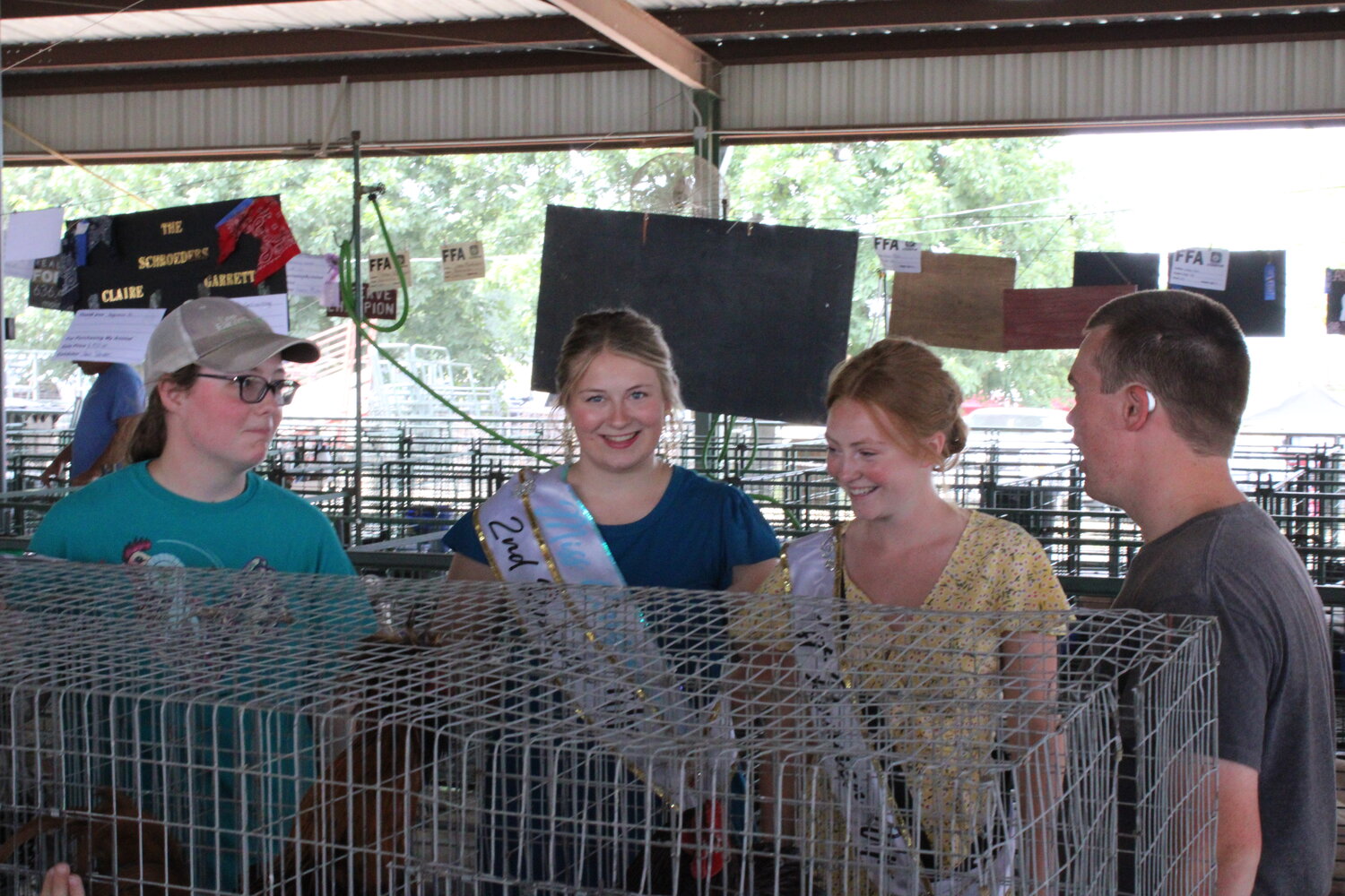 Doralynn Lee and Rhett Karrenbrock talk with queen's court members Grace Schlansker and Allison Duncan during the Warren County Fair's rooster crowing competition.