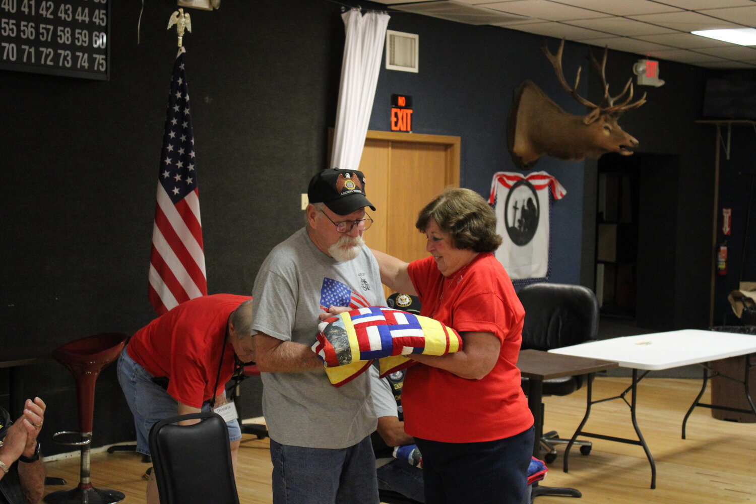 Rob Miller and Marlene Walton look at the quilt presented to the Warrenton veteran in honor of his military service.