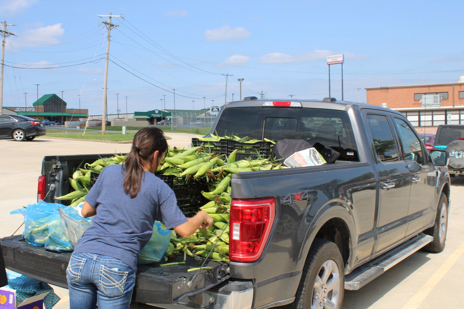 A vendor unloads corn from a truck before the start of the Aug. 1 market in Warrenton.