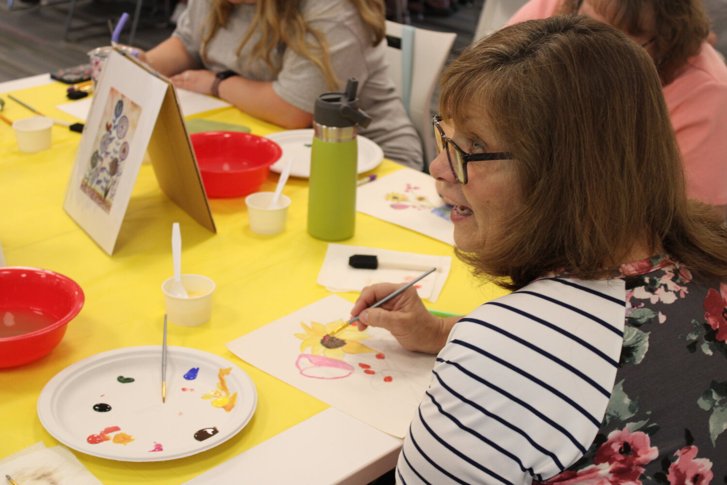 Kim Barnes works on her watercolor painting.