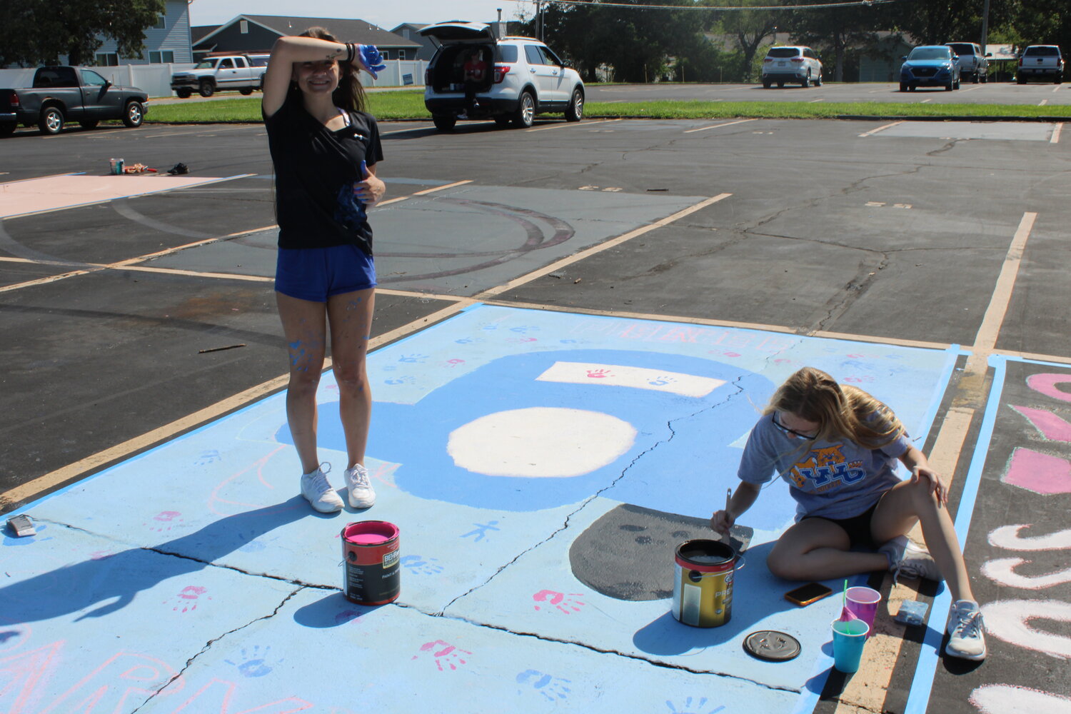 Incoming Wright City seniors Cloe Stuart and Mackenzie Reynolds work on painting a parking spot as part of the new high school tradition during the Aug. 11 event.