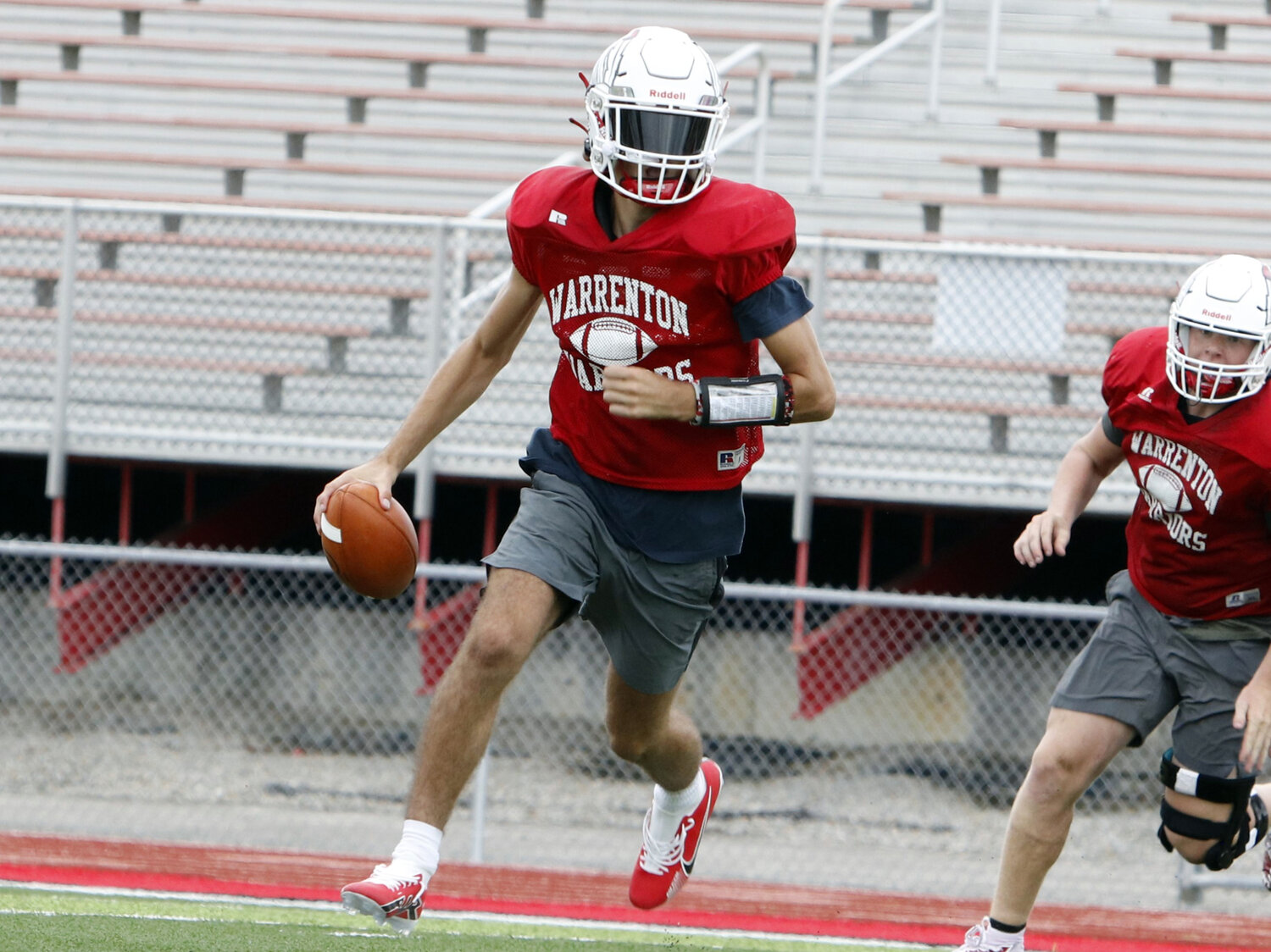 Quarterback Charlie Blondin rolls out to the right during an August practice.