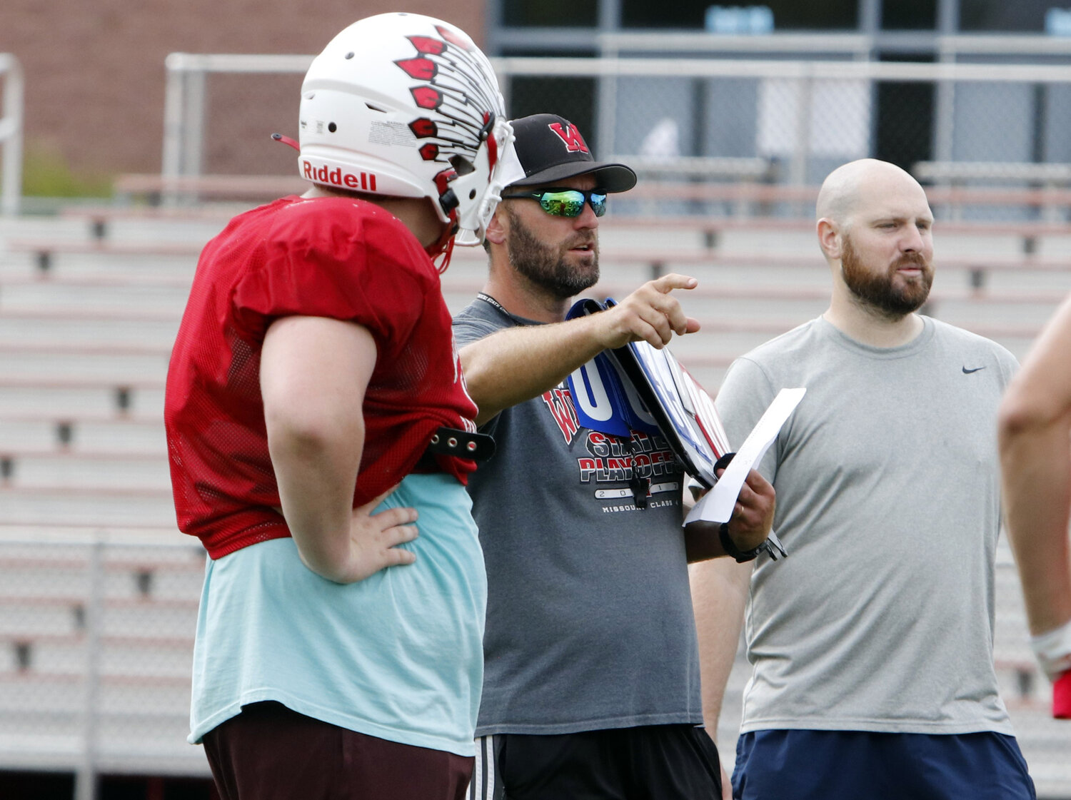 Head Coach Jason Koper speaks with the Warrenton players during practice earlier this month.