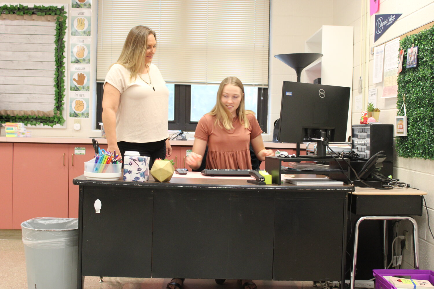 Genessa Gieson looks over the shoulder of her daughter, Hope Roetemeyer, as Roetemeyer works on her classroom computer. Both are first year teachers in the Warren County R-III school district this year.