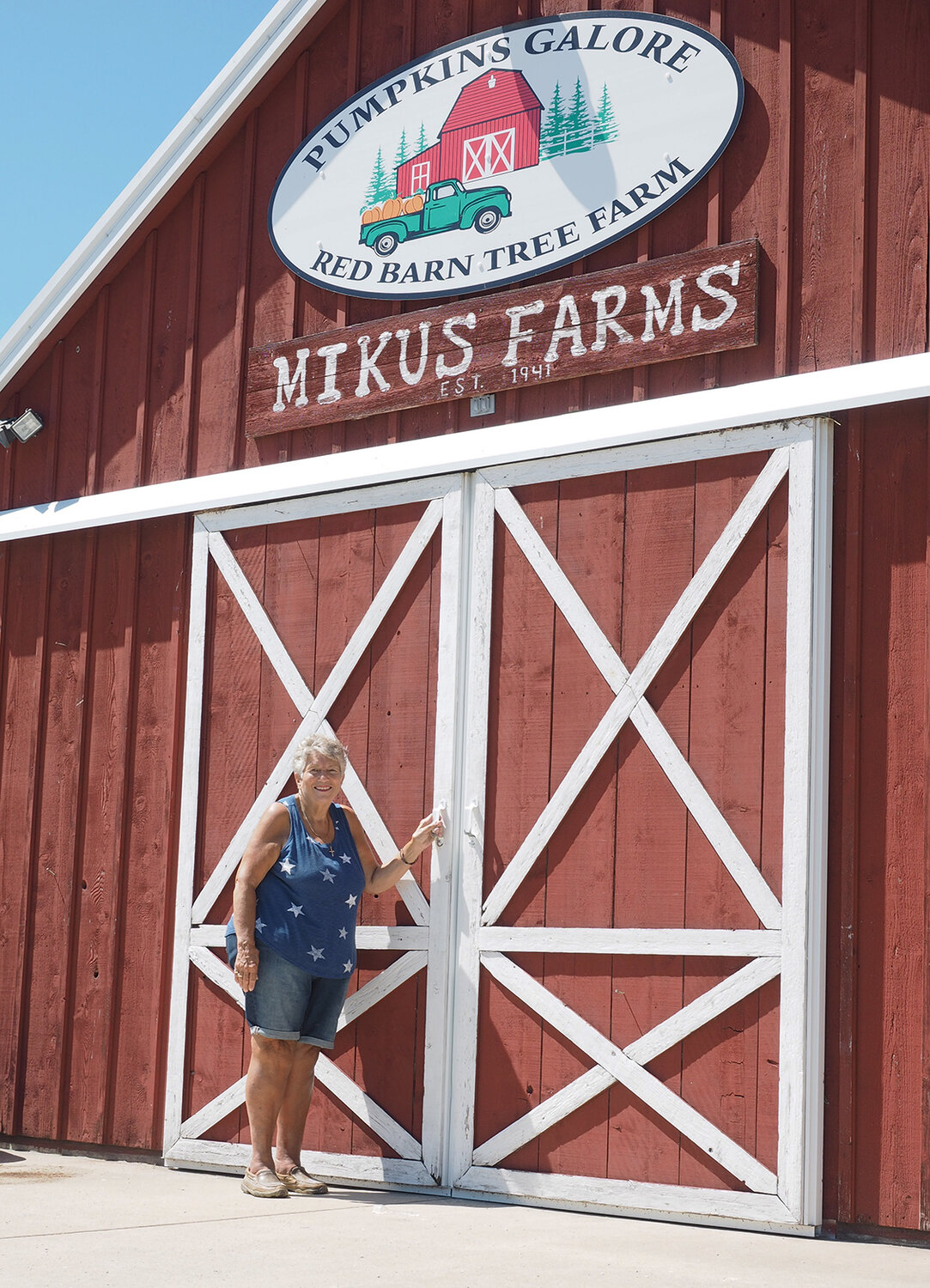 Ardell Mikus poses outside the Mikus Farms barn.