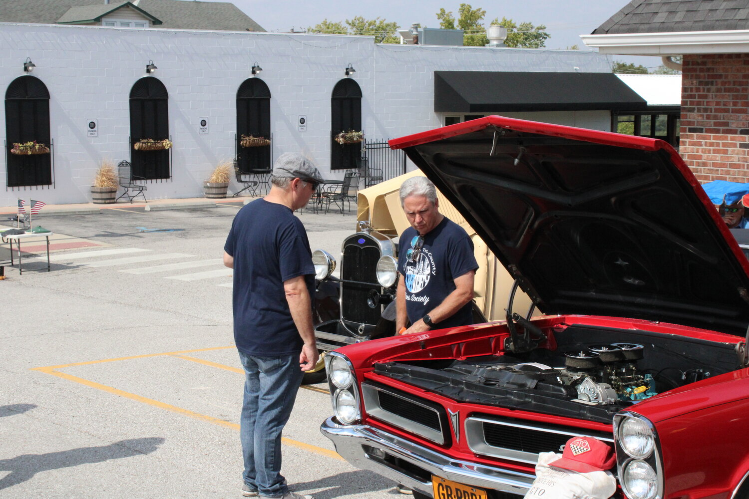 Two men check out one of the cars during the Fall Festival car show.
