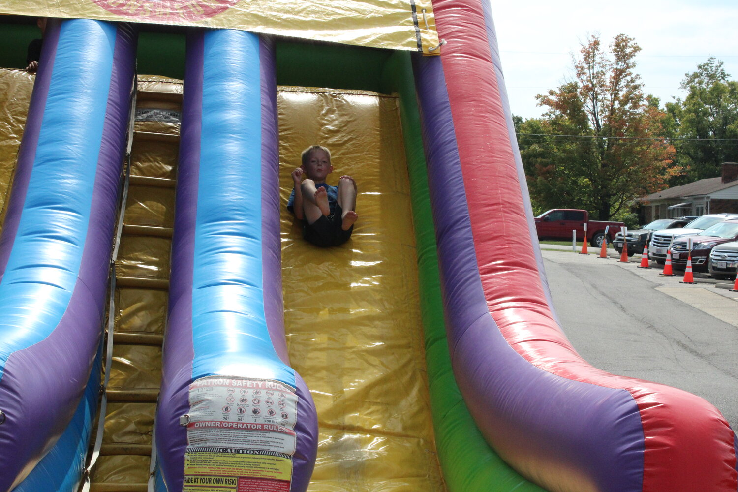 A boy takes the slide in the children's area of the Fall Festival.