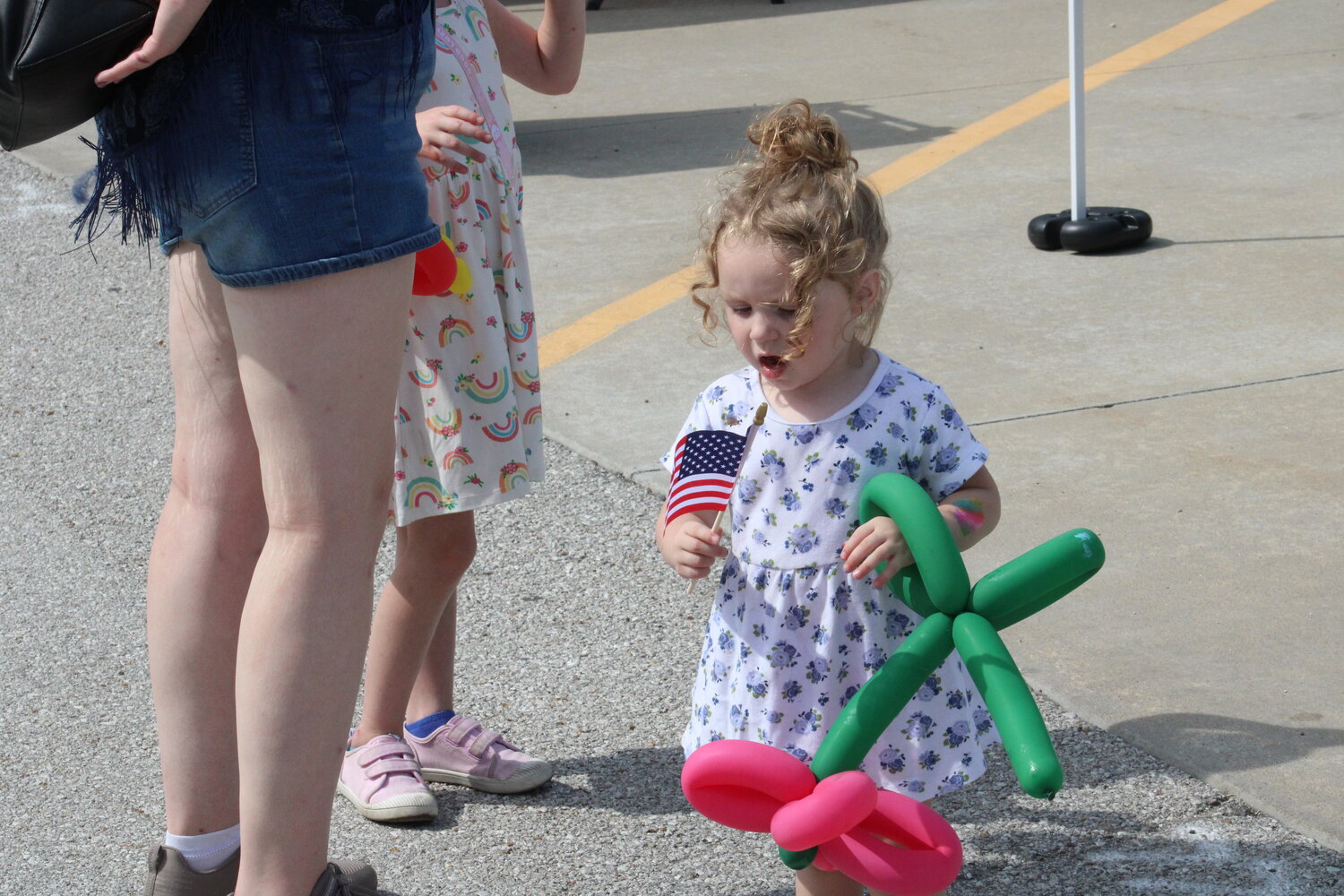 A young girl waves her flag and carries her balloon creation during the Fall Festival.