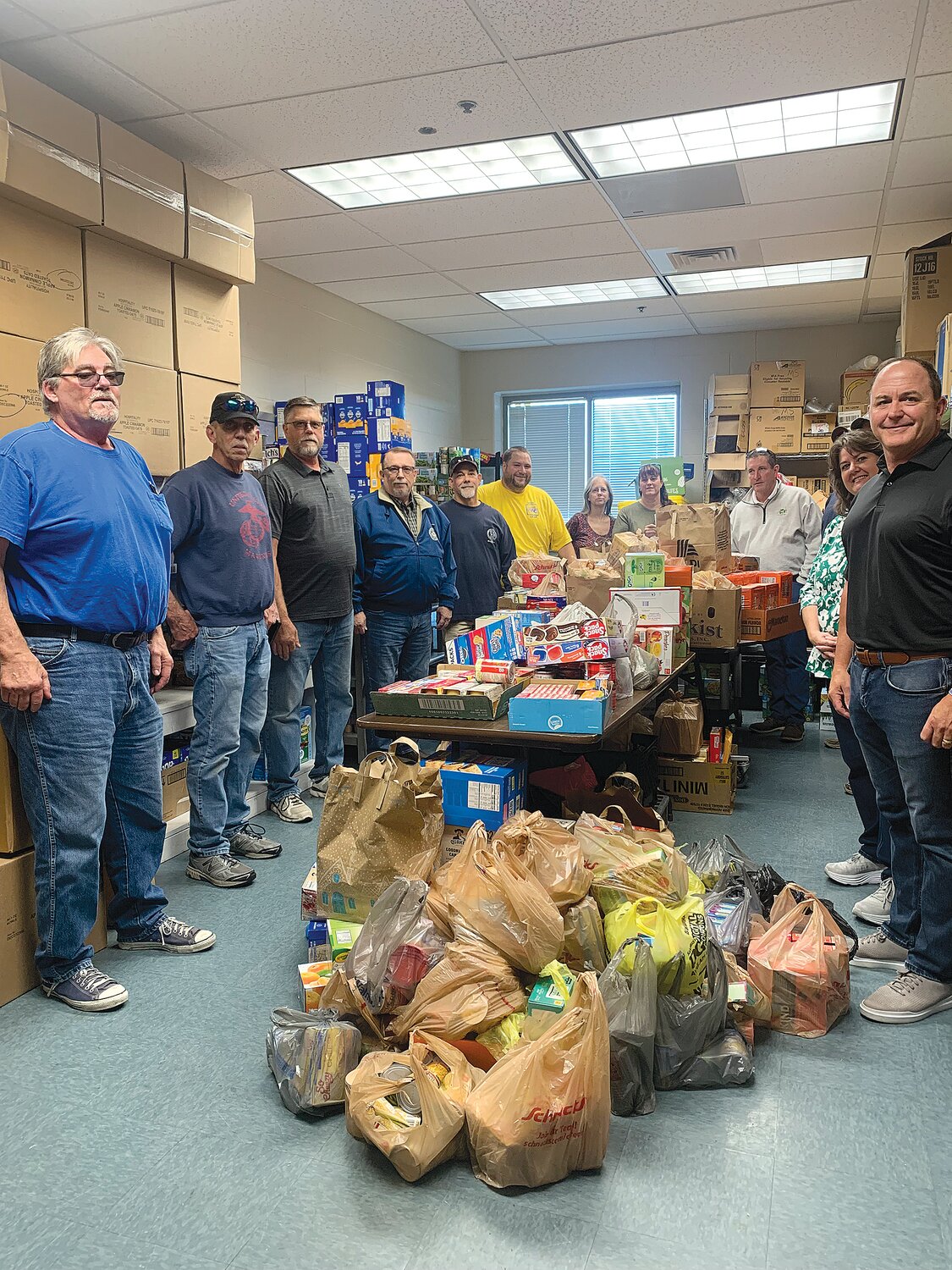 Members of Warren County Labor pose with some of the food they donated to the Wright City school district.