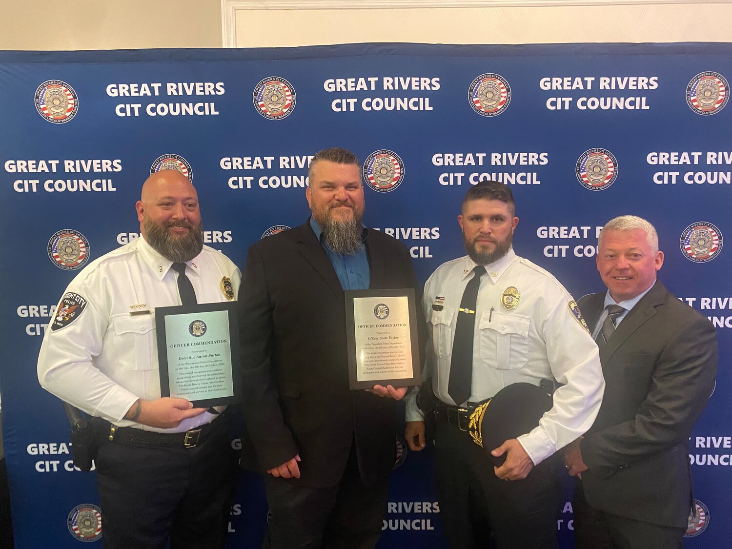 Wright City Detective Aaron Sutton and Officer Scott Taylor pose with their plaques next to Truesdale Police Chief Casey Doyle and Wright City Police Chief Tom Canavan.