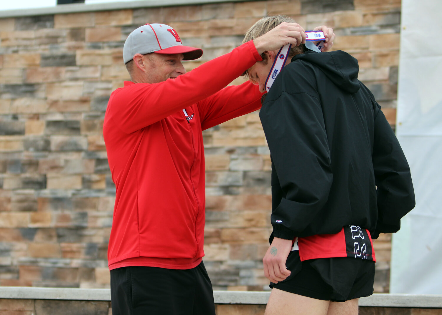 Phillip Kackley (right) receives his state medal from Warrenton head coach Jeremy Collins.