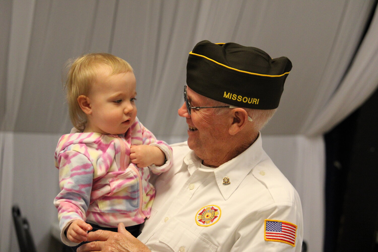 A veteran holds the youngest attendee of the ceremony in Warrenton.