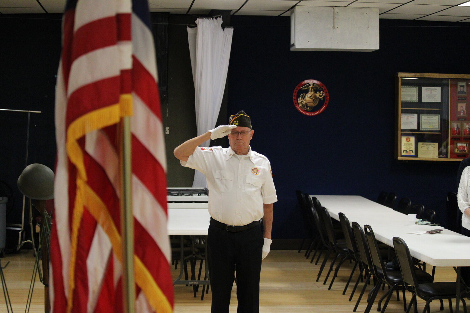 A member of the color guard salutes the American flag while the national anthem is sung.