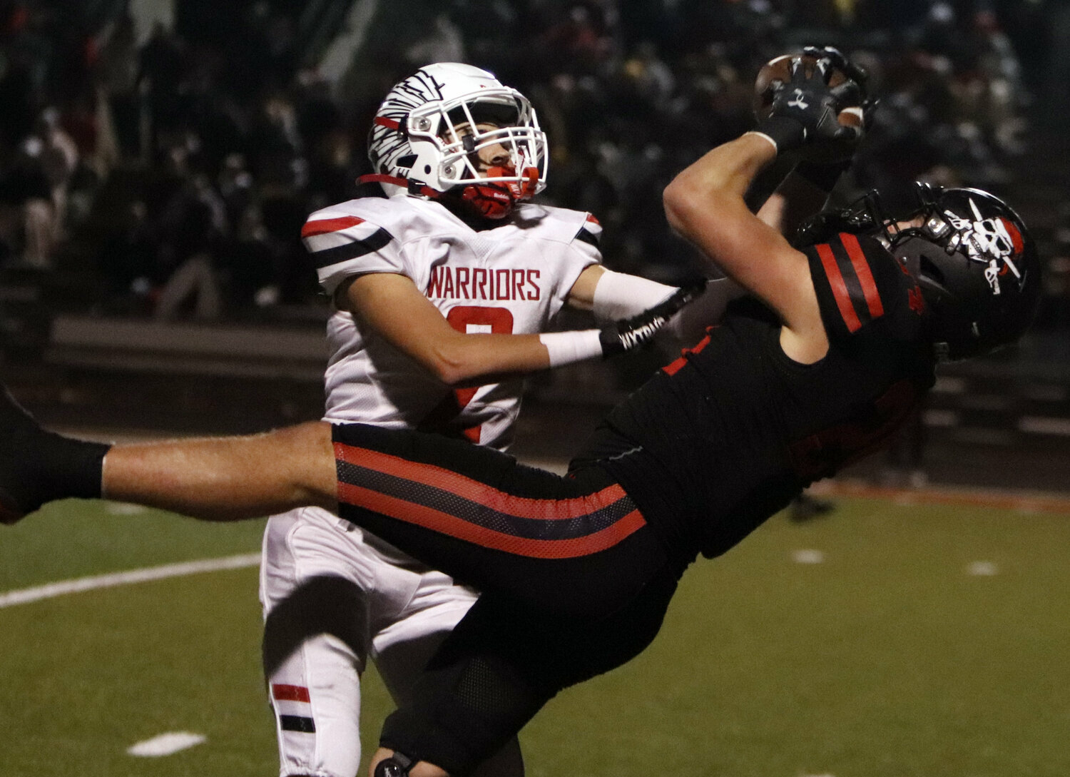 Warrenton's Brandon Johnson attempts to knock the ball loose while covering a Hannibal receiver during the Class 4, District 4 championship game.