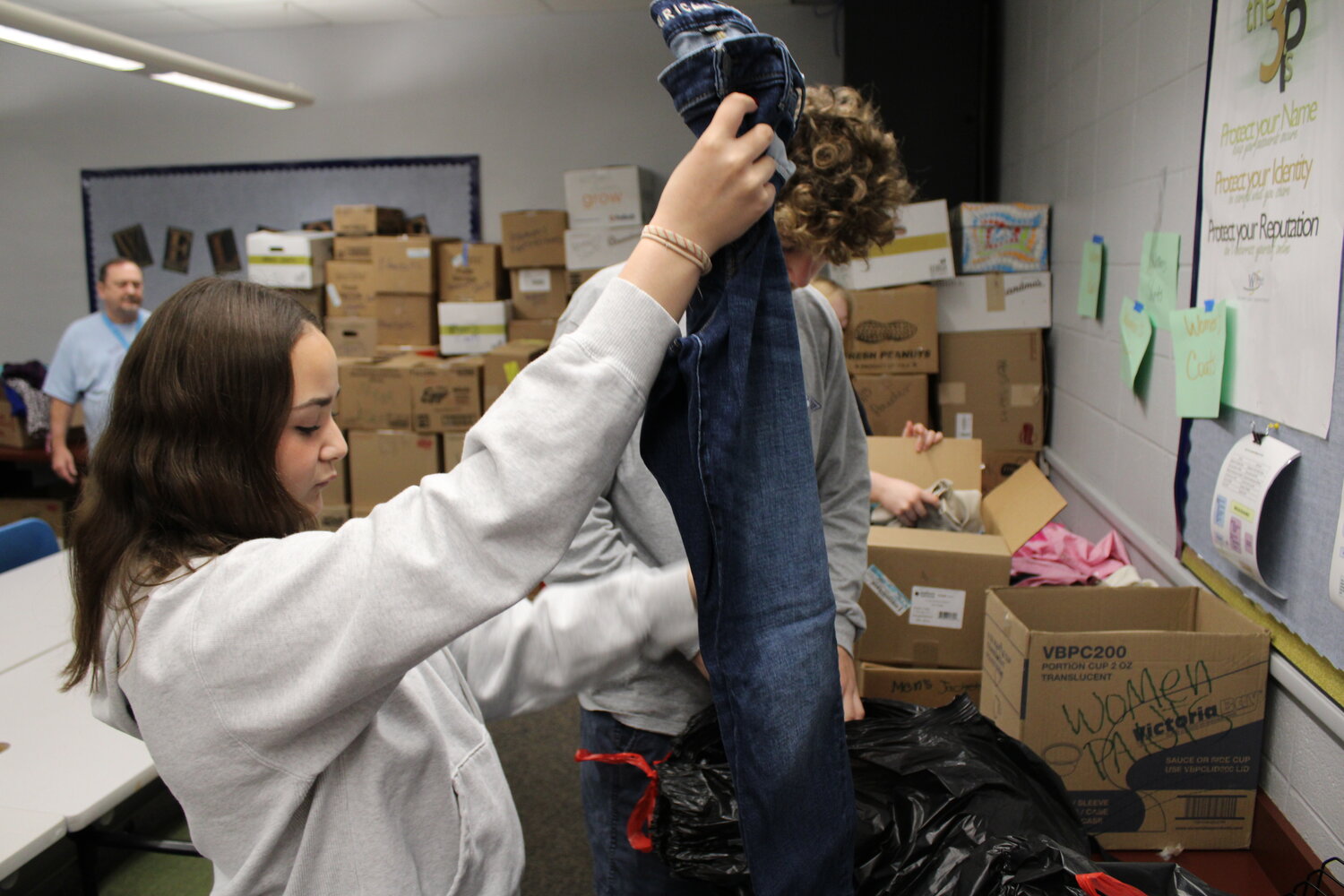 McKenzie Fry inspects a pair of jeans donated to help homeless veterans.