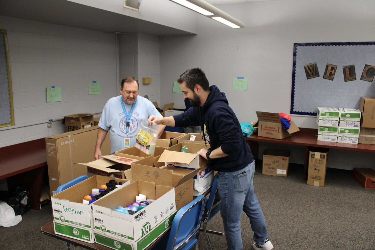 Truesdale Mayor Jerry Cannon, who also serves as the student council sponsor at Wentzville Middle School, and his co-sponsor, Josh Lanham, sort through personal items that were donated to help homeless veterans.