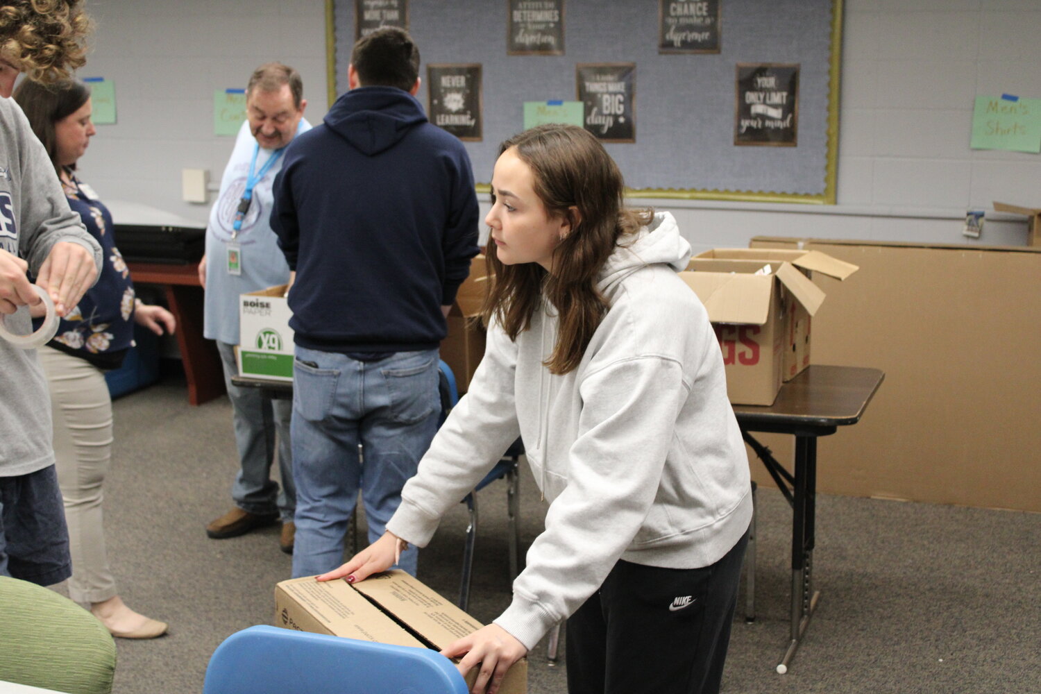 McKenzie Fry tapes a box to make it ready to store donated items in.