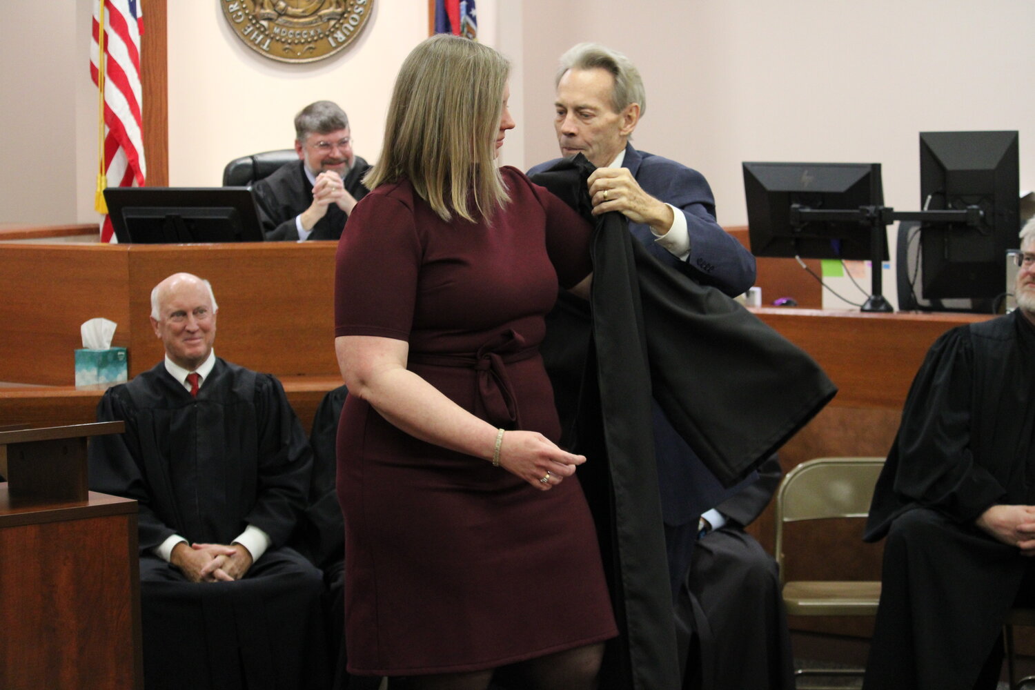 Katie Joyce receives her judges robe from her father, retired attorney Tim Joyce, during the ceremony.