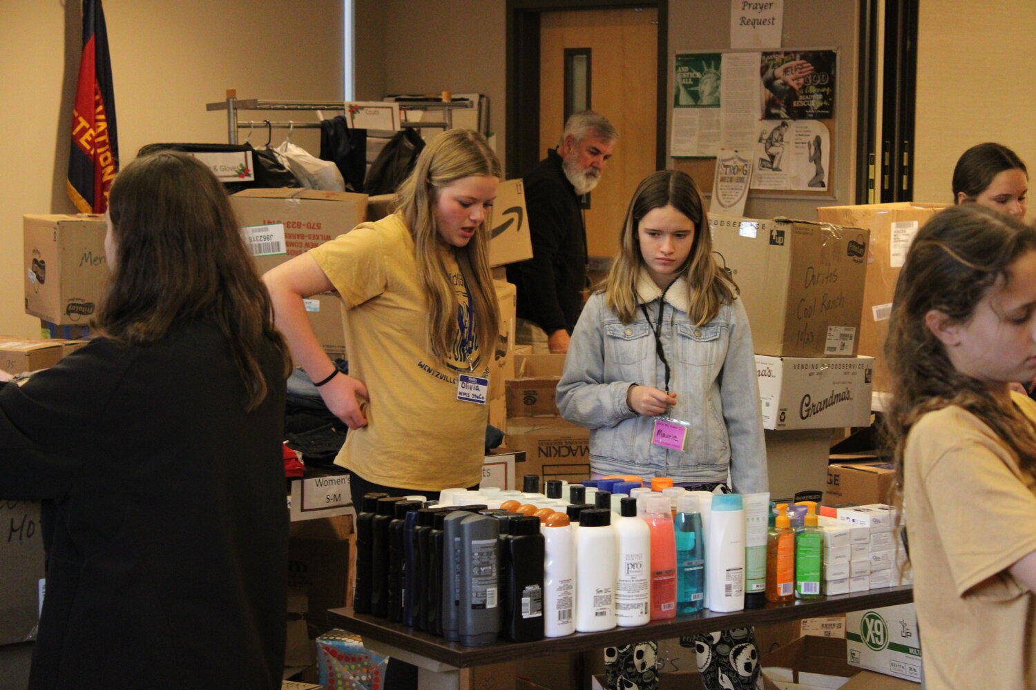 Two Wentzville Middle School students go through the donated toiletry items, helping to set them on a table for homeless individuals to collect.