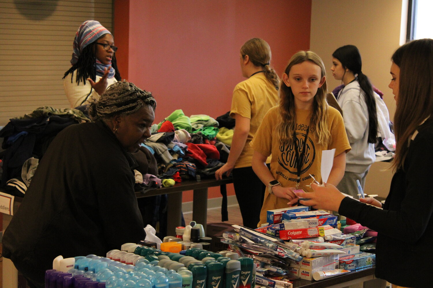 Two Wentzville Middle School students help a person through the line of donations.