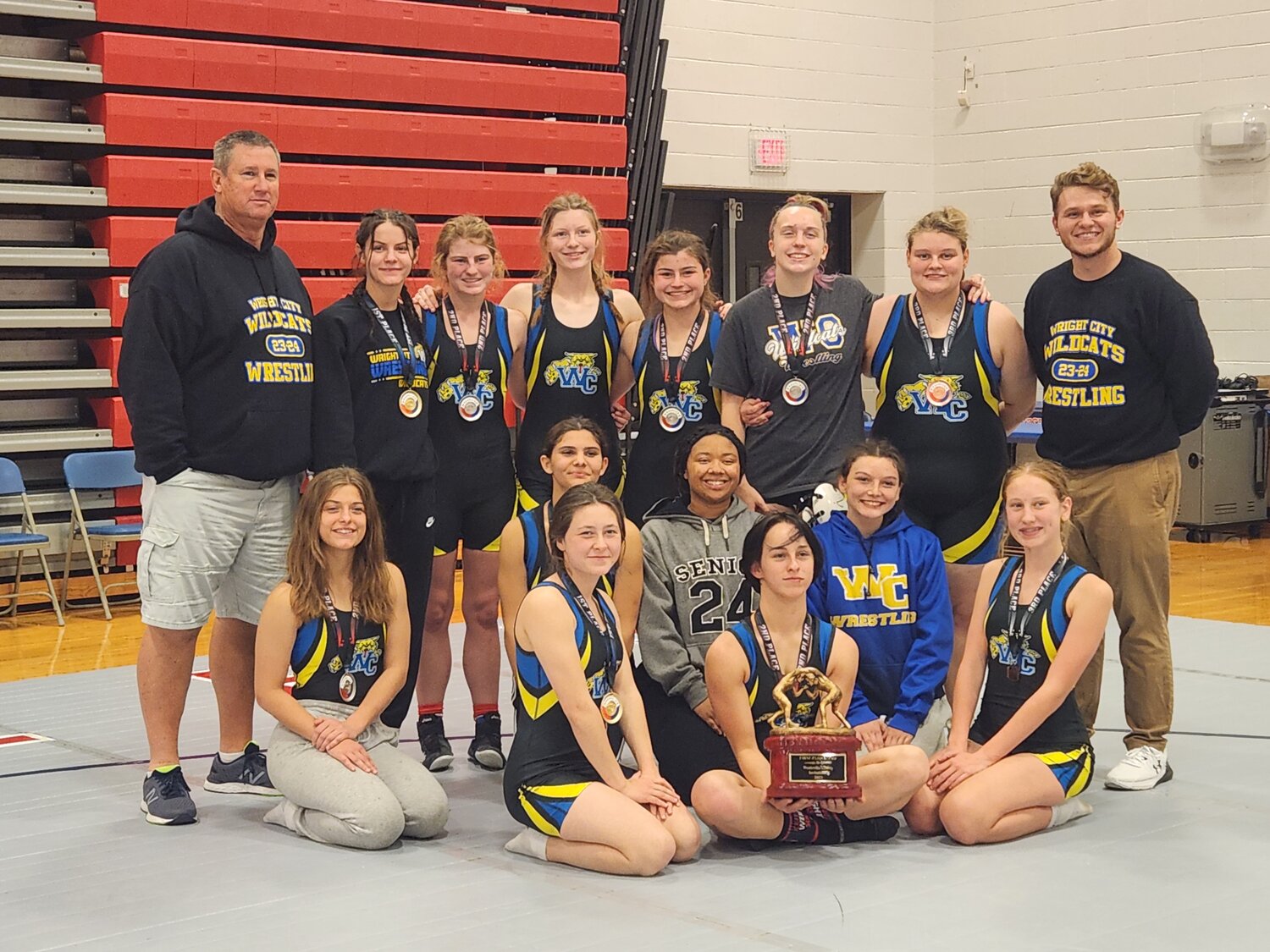Members of the Wright City girls wrestling team pose with the championhip trophy after winning the Liberty Invitational. The Lady Wildcats have won two tournaments this season.