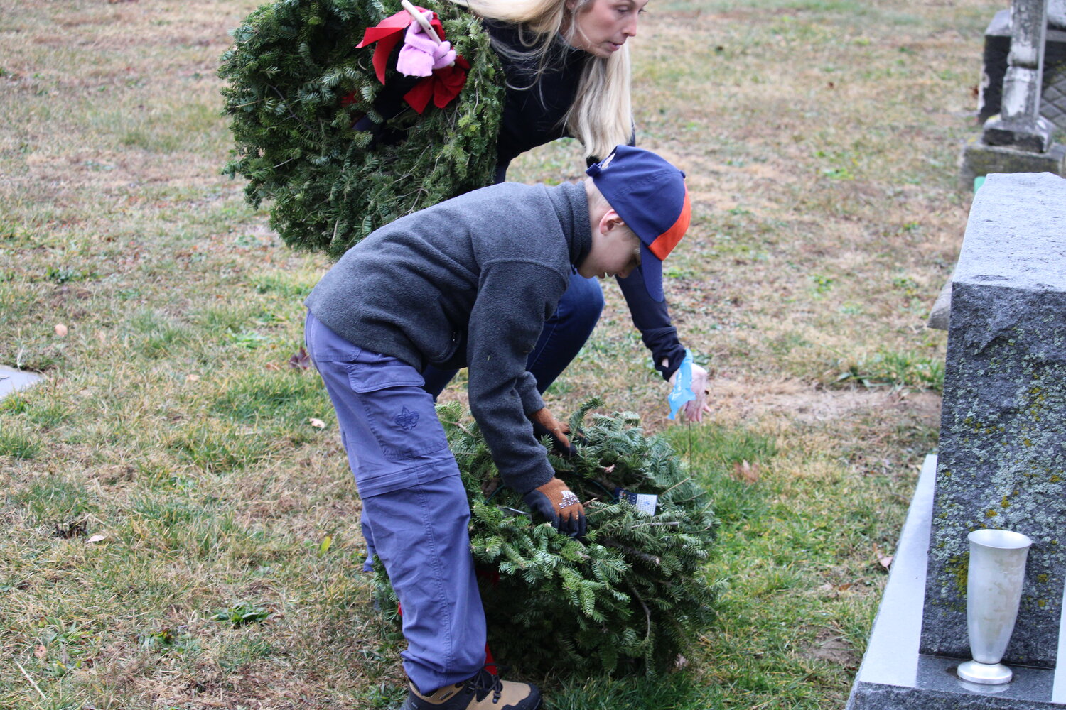 Easton Woldanski lays a wreath to honor a veteran at the Warrenton City Cemetery.