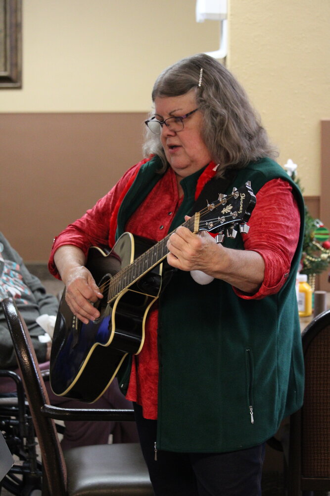Terry Brown plays the guitar as she leads Warrenton Manor residents in a variety of Christmas songs.