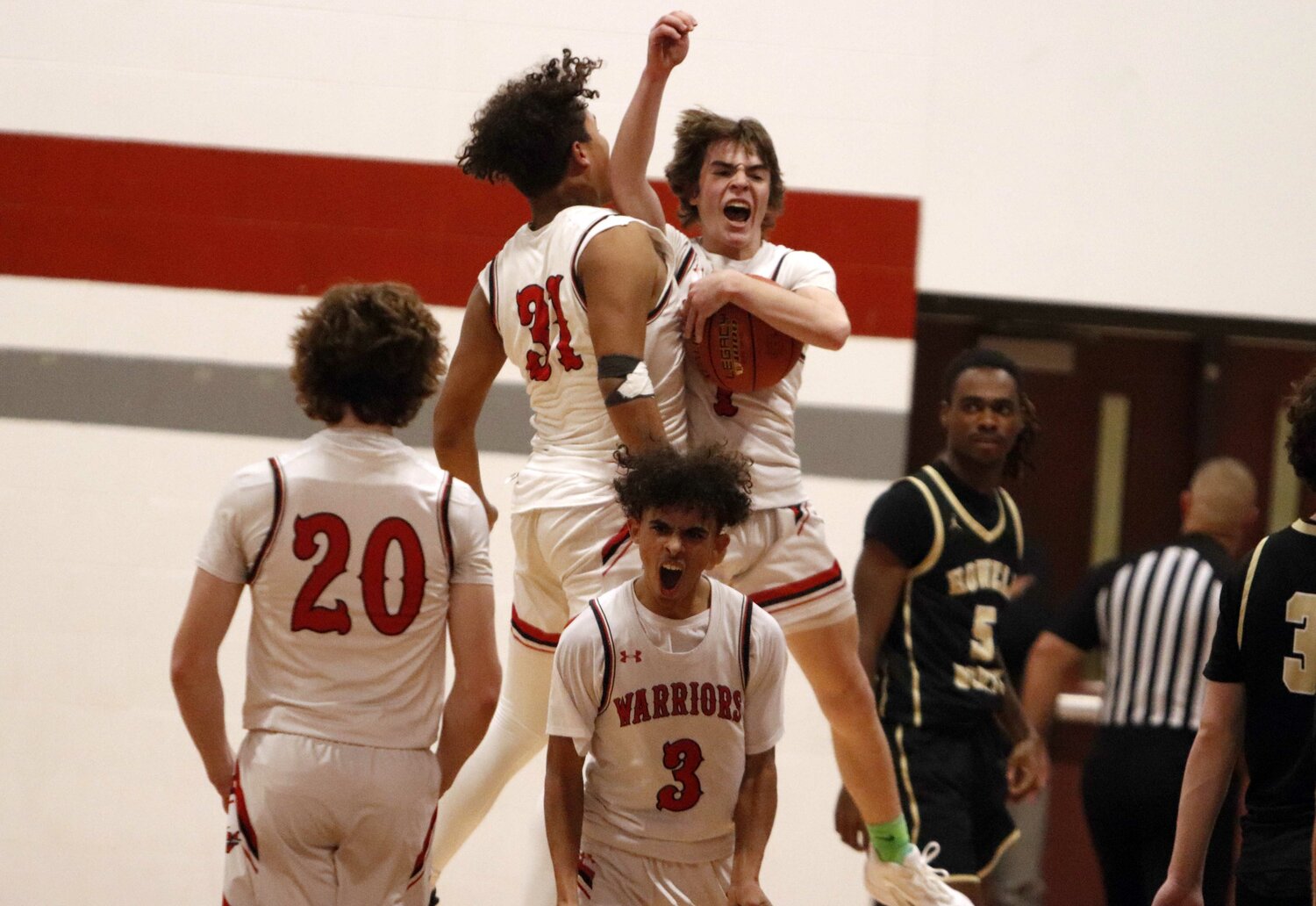 Members of the Warrenton basketball team celebrate after the final buzzer of Warrenton’s 41-35 overtime win over Francis Howell North.