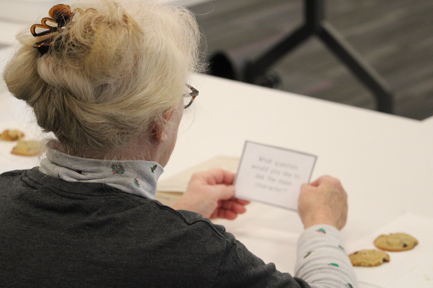 A member of the Literary Traveler’s book club reads her discussion question during the Dec. 27 meeting.