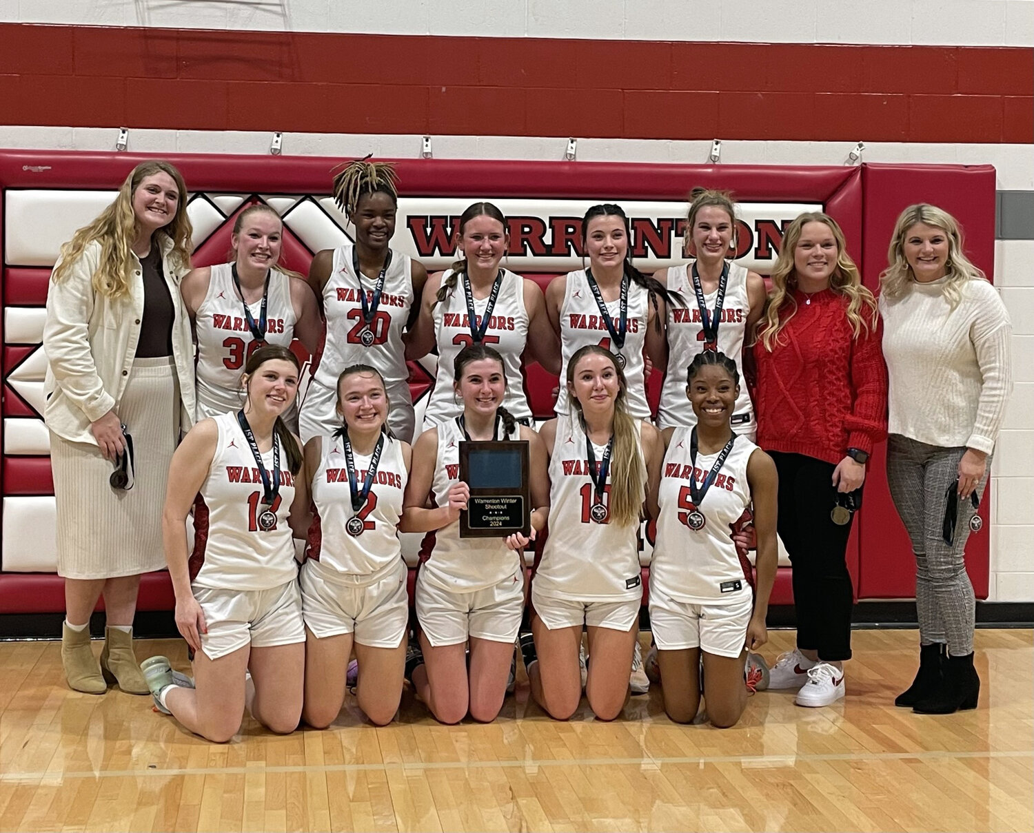 Members of the Warrenton girls basketball team pose with the championship plaque after winning the 2024 Warrenton Winter Shootout.