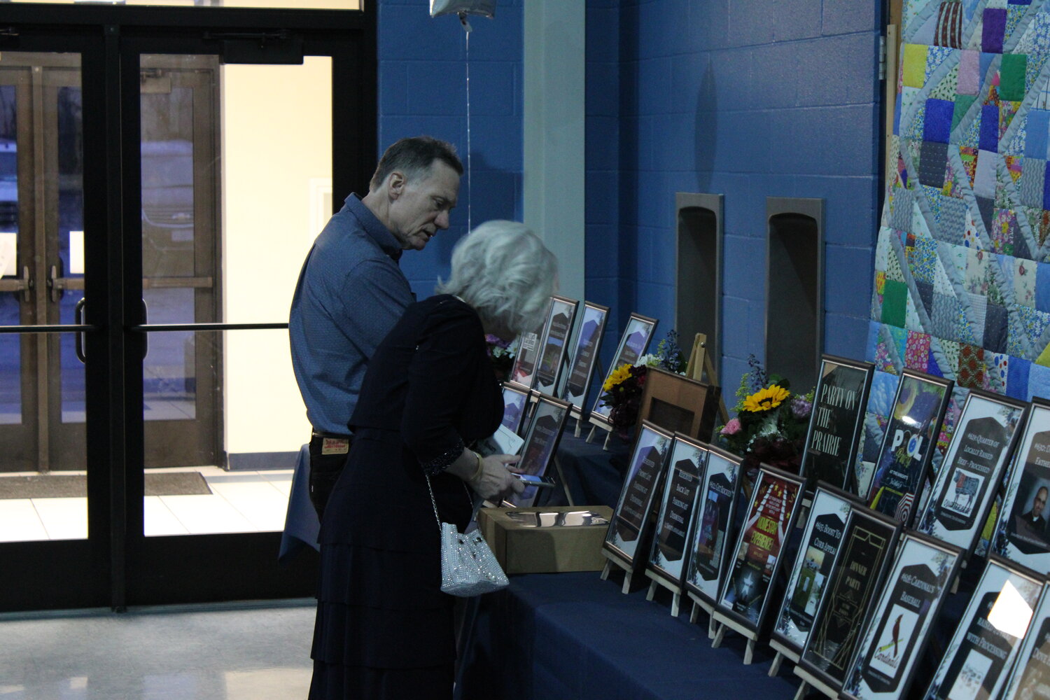 Principal Mary Wooley checks out the items up for auction before the dinner begins.