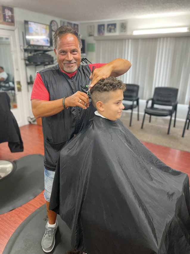 Dave Picozzi, seen here cutting the hair of a young man and now loyal customer at David’s Greenwood Barber Shop, has been a barber for over 30 years .Walk-ins only at this longstanding shop in Warwick.
