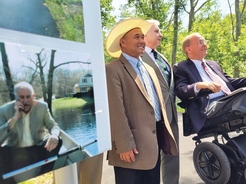 TWO IF BY SEA: Phou Vongkhamdy, U.S. Sen. Jack Reed and U.S. Rep. James Langevin stand near a poster, featuring a photo of Johnston Mayor Joseph M. Polisena in a boat.