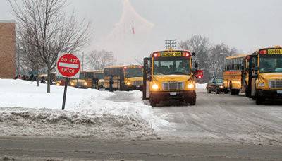 BUSES CURBED: School buses lined up on a winter day in 2011. During the pandemic, however, the district has had a hard time keeping buses on the road to transport students to school. On Tuesday, Dec. 14, 2021, the Johnston School District announced there would be no bus service because so many drivers were in quarantine following substantial COVID-19 virus outbreaks in Johnston schools.
