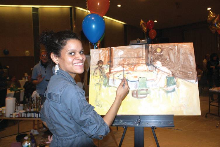IT IS ALL IN THE SCENERY: Camille Chedda, a &ldquo;dueling artist&rdquo; who was born in Jamaica where she studied painting at the Edna Manley College of the Performing Arts, works on her canvas. In 2010, she enrolled as a graduate student, majoring in painting, at UMass Dartmouth. She decided to paint what was right in front of her, a table of guests there that evening.