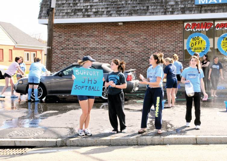 The players advertise their car wash, including (at center) Lindsey Haskins, Lexi Waters and Helen Hanley.